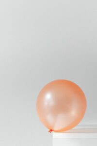 orange balloon on white surface